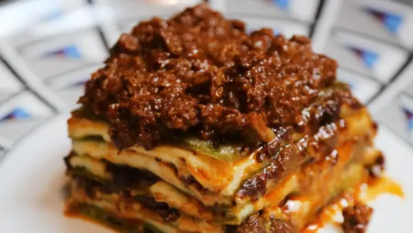 Una porzione di lasagne al ragù, stratificata con pasta, besciamella e un ricco ragù di carne.