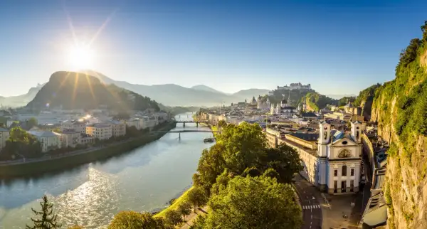 Sonnenaufgang über Salzburg. Die Salzach fließt durch die Stadt, im Hintergrund die Festung Hohensalzburg. Ein perfekter Morgen für smbs salzburg.