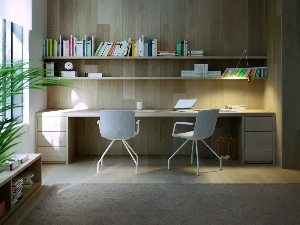 Un moderno ufficio in casa con scrivania in legno, sedie grigie, libreria piena e una pianta verde. Idee per un ambiente di lavoro funzionale e accogliente.