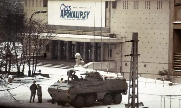 Wóz bojowy na śniegu, ludzie w mundurach, budynek z napisem "Czas Apokalipsy". Atmosfera przypomina stan wojenny.