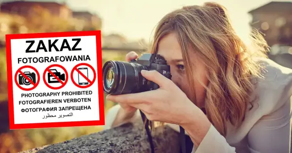 Kobieta z aparatem ignoruje znak zakaz fotografowania.