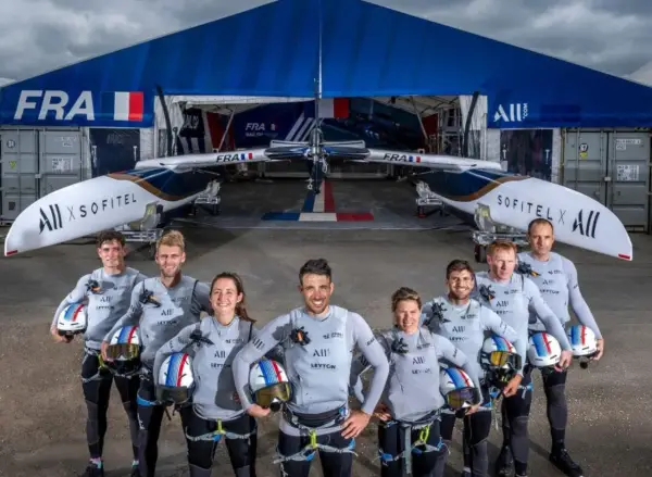 L'équipe française du SailGP France pose fièrement devant son catamaran, prête à conquérir les océans.