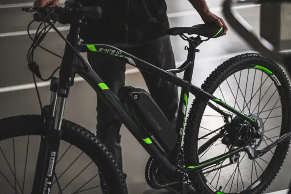 Czarny rower elektryczny z zielonymi akcentami i baterią Green Cell. Dowiedz się, jak sprawdzić baterię w rowerze elektrycznym.