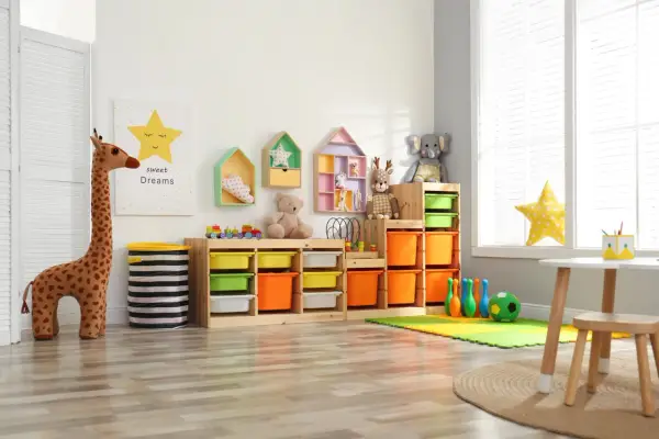 Bunte Kisten und Regale bieten tolle **Lego Aufbewahrung Ideen** für ein aufgeräumtes Kinderzimmer. Spielzeug-Giraffe und Teddybär bewachen die Ordnung.