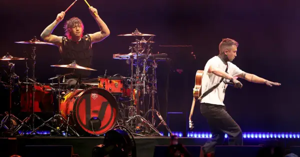 Tyler Joseph śpiewa, a Josh Dun gra na perkusji podczas koncertu twenty one pilots.