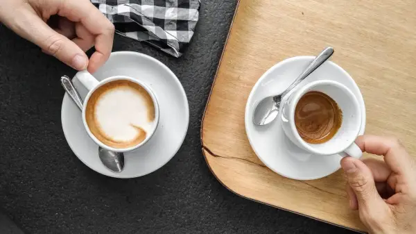 Zwei Espresso auf italienisch, einer mit Milchschaum, der andere schwarz, bereit zum Genießen.