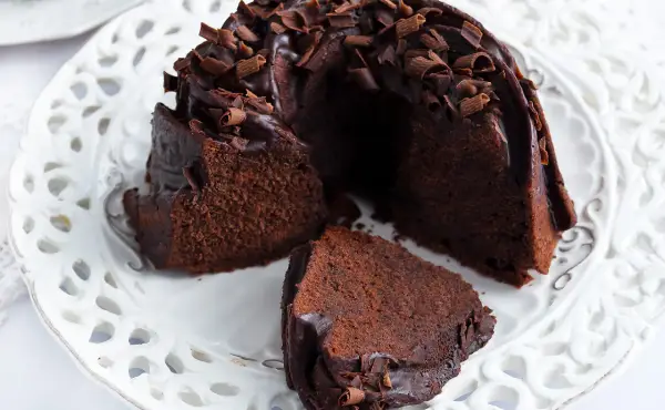 Pyszna babka z mascarpone i kakao, polana czekoladą i posypana wiórkami. Idealna na deser.