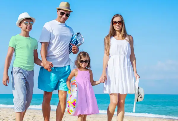 Rodzina na plaży, idealne miejsce, gdzie na wakacje z dziećmi. Słońce, morze i uśmiechy.