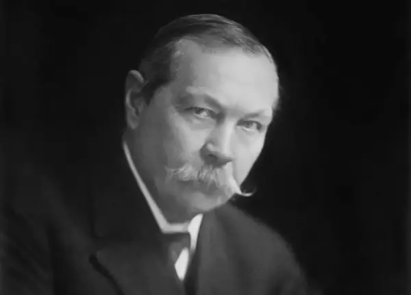 Sir Arthur Conan Doyle, kto jest autorem książek o Sherlocku Holmesie, na czarno-białym portrecie.