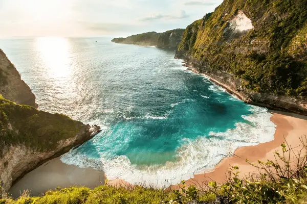 Idealne wakacje na Bali: turkusowa zatoka otoczona klifami, złoty piasek i szum fal. Raj na ziemi.