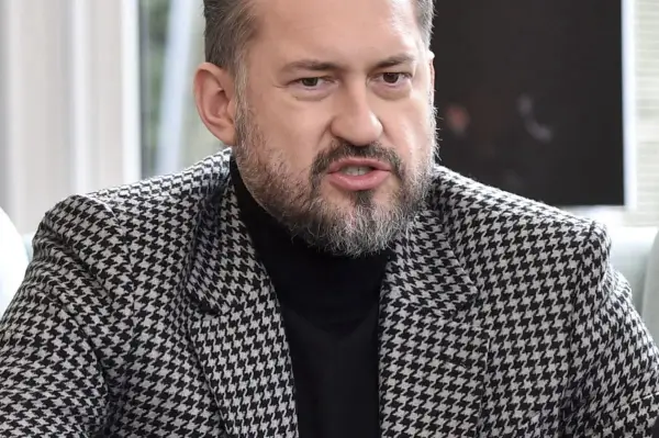 Marcin Prokop w czarnej golfie i marynarce w pepitkę.