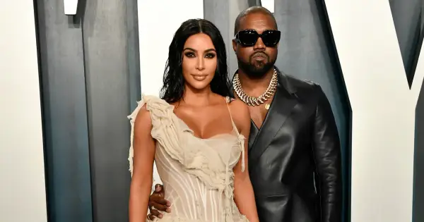 Kim Kardashian i jej mąż, Kanye West, pozują do zdjęć w eleganckich strojach.