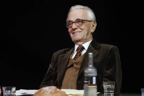 Uśmiechnięty Andrzej Łapicki w eleganckim garniturze, wspominający swoje filmy.