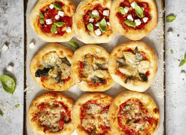 Mini pizze z mozzarellą, bazylią, pomidorami, karczochami i szpinakiem. Wiele opcji, co można dać na pizzę!