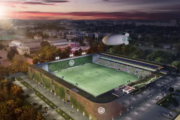 Nowoczesny stadion Warty Poznań z zielonymi fasadami i sterowcem nad boiskiem.