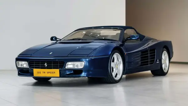 Niebieskie Ferrari 512 TR Spider z lat 90. błyszczy na wystawie, gotowe na przejażdżkę.