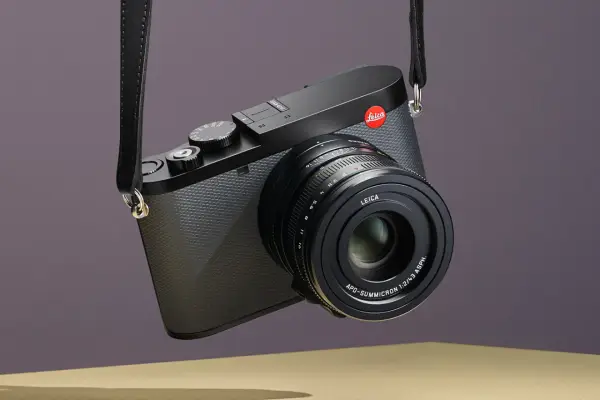 Elegancki aparat Leica z paskiem, gotowy do uchwycenia niezapomnianych chwil. Idealny do fotografii podróżniczej.