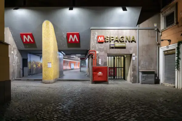 Ingresso del subte Roma, stazione Spagna, con insegna dorata e pavimentazione in sampietrini.