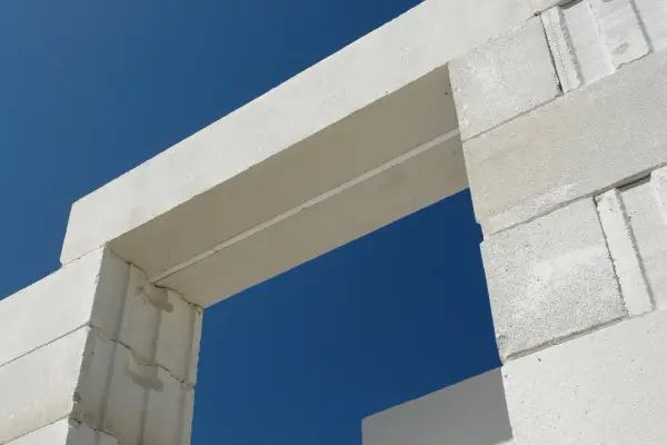 Białe nadproże nad drzwiami 90, wykonane z bloczków z betonu komórkowego, na tle błękitnego nieba.