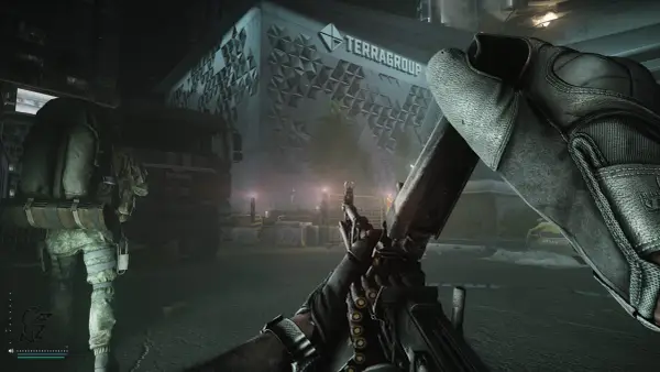 Gracz z karabinem w rękach, gotowy do akcji w grze Escape from Tarkov na PS5. W tle budynek TerraGroup i ciężarówka.