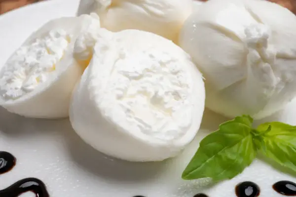 Świeża burrata co to? Delikatny ser z kremowym wnętrzem, podany z bazylią i balsamicznym sosem.