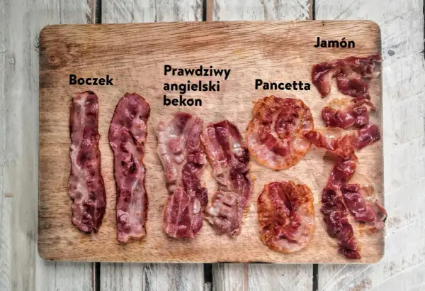 Różne rodzaje boczku: polski, angielski, pancetta i jamón, ułożone na desce.