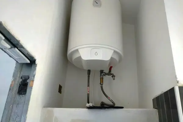 Scaldabagno elettrico bianco con tubi e rubinetto. Potrebbe esserci aria nello scaldabagno elettrico, ma l'immagine non lo mostra.