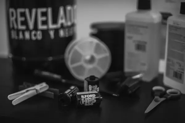 Utensilios para revelar fotos en blanco y negro: carretes Ilford, tijeras, pinzas y botes de químicos.