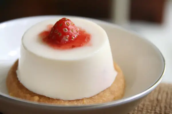 Panna cotta à la fraise sur un biscuit. Si elle est trop liquide, pas de panique, voici comment rattraper une panna cotta trop liquide.