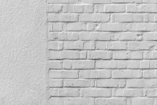 Mur blanc texturé à gauche, briques blanches à droite. Idéal pour un devis de prix piquage et rejointoiement.