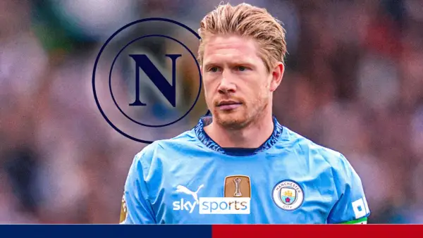 Kevin De Bruyne w koszulce Manchesteru City z logo Napoli w tle.
