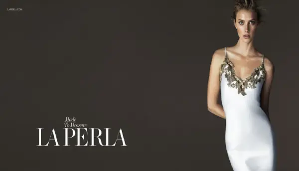 Model in a white slip dress with gold lace trim, with "LA PERLA" logo.