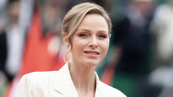 La princesa de Mónaco, Charlene Wittstock, sonríe con un traje blanco a rayas.
