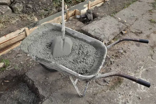 Taczka z betonem i łopatą, gotowa do wykonania zbrojenia ławy fundamentowej 40x60.