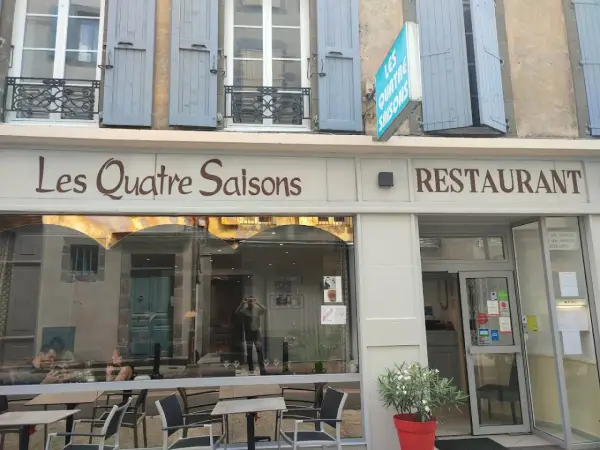 Le restaurant étoilé Les Quatre Saisons à Aurillac, une façade accueillante avec une enseigne lumineuse.