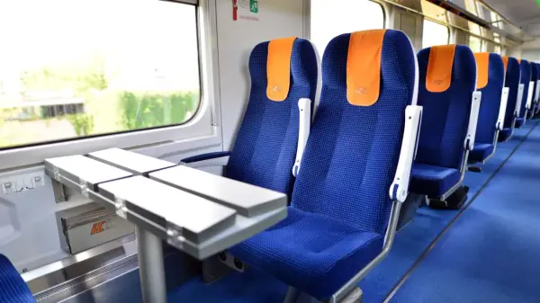 Wygodne siedzenia w pociągu PKP Intercity, gotowe na podróż do Warszawy.