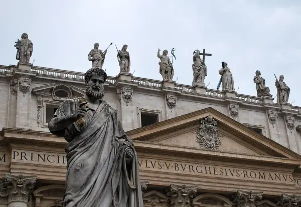 Kamienna postać z kluczem w dłoni, na tle bazyliki. Czy mantry są niebezpieczne? Ta rzeźba nie daje odpowiedzi.