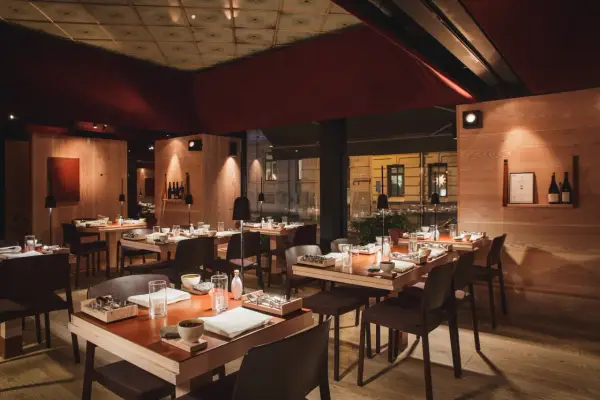 Elegant inredning på en michelin restaurang i Sverige. Vackert dukade bord med trädetaljer och dämpad belysning skapar en intim atmosfär.