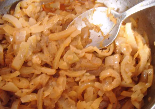 Smażona cebula z przyprawami, wygląda jak pyszna omasta do pierogów.
