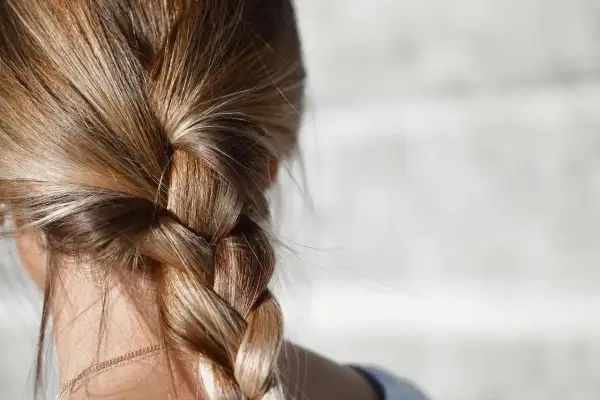 Gładki warkocz z blond włosów, idealny przykład, jak zmniejszyć porowatość włosów.