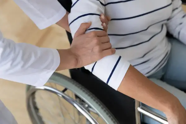 Opiekunka pomaga osobie na wózku inwalidzkim. Czy świadczenie pielęgnacyjne wlicza się do lat pracy?