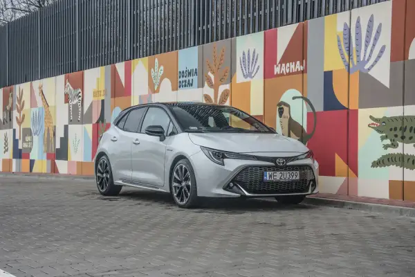 Srebrna Toyota Corolla GR na tle kolorowego muralu z motywami zwierzęcymi.