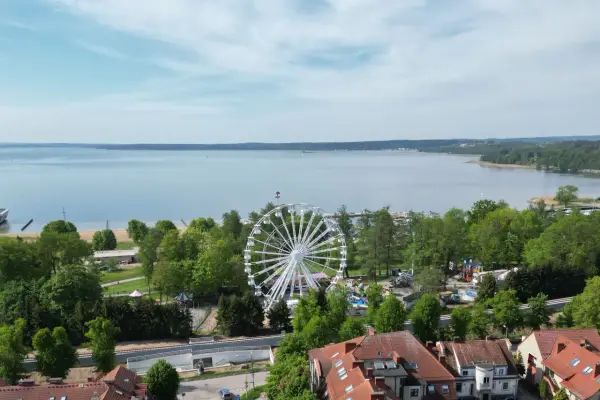 Widok na jezioro i park rozrywki z diabelskim młynem w Giżycku.