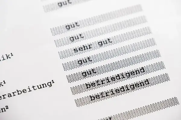 Zeigt eine Liste mit Noten, darunter "gut", "sehr gut" und "befriedigend". Eine schulnote, die die Leistung eines Schülers bewertet.