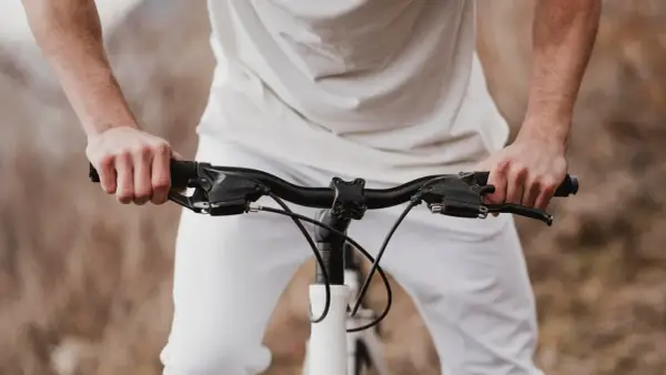 Dłonie na kierownicy roweru szosowego. Zastanawiasz się, jak dobrać szerokość kierownicy szosowej?