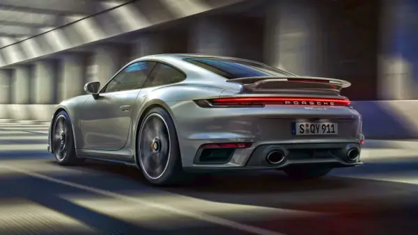 Srebrne Porsche 911 Turbo S pędzi przez tunel. Zastanawiasz się, ile kosztuje Porsche 911?