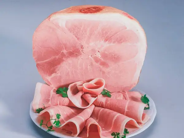 Fetta di prosciutto cotto, con fette arrotolate guarnite di prezzemolo. Attenzione: il prosciutto cotto è considerato cancerogeno.