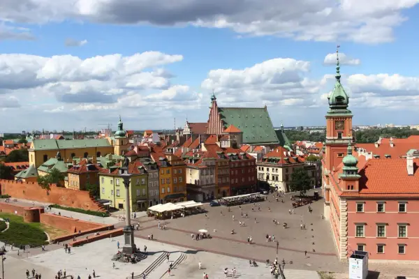 Widok na Zamek Królewski i Rynek Starego Miasta w Warszawie. Kolorowe kamienice, kolumna Zygmunta i tłumy turystów.