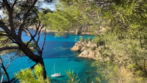 Vue sur la côte rocheuse et la mer turquoise de Bandol, avec des voiliers. Idéal pour savoir que faire à Bandol.