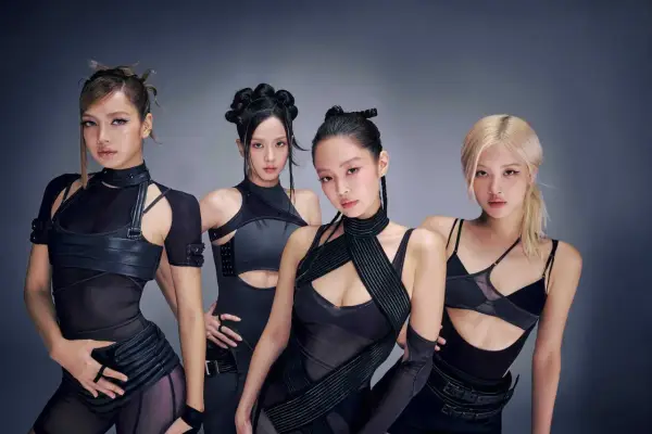 Medlemmar av Blackpink poserar i futuristiska svarta outfits.
